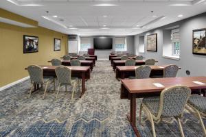 a conference room with tables and chairs and a screen at Andover Inn in Andover