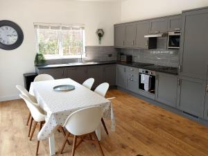 a kitchen with a table and chairs in a kitchen at Apple Lodge in Bovey Tracey