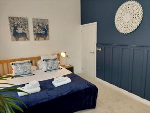 a bedroom with a bed with towels on it at Apple Lodge in Bovey Tracey