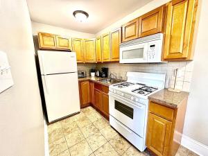 uma cozinha com electrodomésticos brancos e armários de madeira em Peaceful & Perfect Private 1-br em Filadélfia