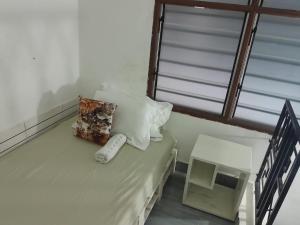 a room with a bed with a pillow and a window at Happy Homes in Mombasa