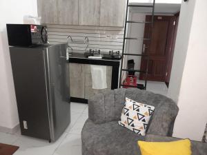 a living room with a chair and a kitchen at Happy Homes in Mombasa