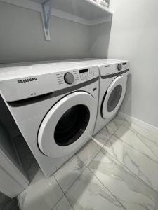 a washing machine is sitting in a room at Prime Retreat: Cozy 2Bed Bsmnt with Modern Comfort in Nisku