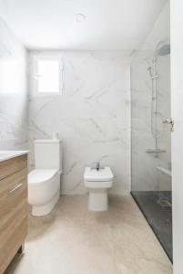 a white bathroom with a toilet and a sink at private room in shared apartment Valencia WorkStay in Valencia +13 photos