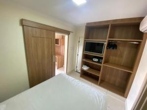 1 dormitorio con 1 cama y TV de pantalla plana en Lacqua diRoma Hotel com Parque Aquático 24 horas, en Caldas Novas
