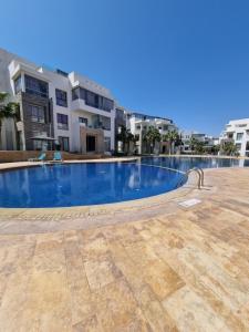een leeg zwembad voor sommige gebouwen bij L3 avec piscine in Agadir