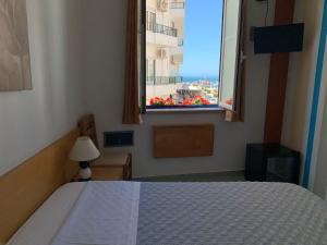 a bedroom with a bed and a window with a view at WEAA Hotel in Nazaré