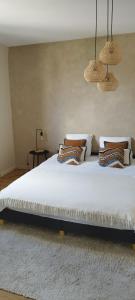 sypialnia z dużym białym łóżkiem z poduszkami w obiekcie Au pied du mur w mieście Huy