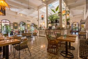 ein Restaurant mit Tischen und Stühlen in einem Raum in der Unterkunft Al Alma Apart-Suites in Cartagena de Indias