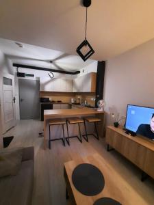 un soggiorno con divano e tavolo e una cucina di Aparthouse Zegrze a Serock