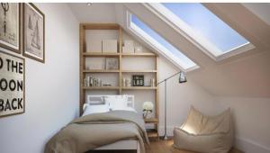 Schlafzimmer im Dachgeschoss mit einem Bett und einem Dachfenster in der Unterkunft Shakespeare inn in London