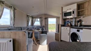a living room with a kitchen and a dining room at Seaside Heaven - Southerness Caravan Rental in Mainsriddle