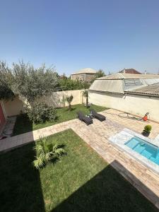 a backyard with a swimming pool and a yard with grass at BakuHome in Baku