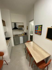 una cucina con tavolo e sedie in legno in una stanza di San Dionigi 11 Studio Apartments a Milano