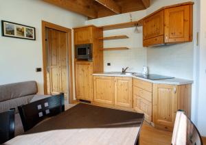 una cocina con armarios de madera y una mesa en una habitación en Casa Giulia, en Bormio