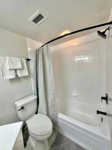 a white bathroom with a toilet and a bath tub at Incredible Apartment with Rooftop in Pentagon City in Arlington