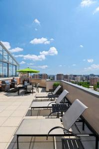 a balcony with chairs and tables on a building at Incredible Apartment with Rooftop in Pentagon City in Arlington