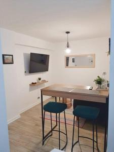 a kitchen with a table and two blue bar stools at Miraflores Beautiful Studio! in Lima