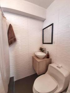 a white bathroom with a toilet and a sink at Miraflores Beautiful Studio! in Lima