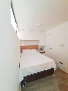 a bedroom with a white bed in a room at Miraflores Beautiful Studio! in Lima