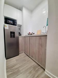 a kitchen with a stainless steel refrigerator and wooden cabinets at Miraflores Beautiful Studio! in Lima