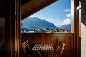 a wooden table and chairs on a balcony with a view at Casa Giulia in Bormio