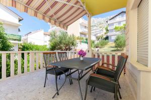a patio with a table and chairs on a balcony at Apartment Jele in Omiš