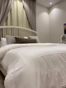 a white bed with pillows and curtains in a room at شقة الأصيل سكن خاص بيوت ضيافة غرفة وصالة مستقلة لا يوجد مصعد درج فقط Al Aseel Apartment Buyoot Al Diyafah in Taif