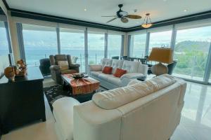 ハコにあるLuxury beach condo, stunning sunset & ocean viewの白い家具付きのリビングルームが備わり、海の景色を望めます。