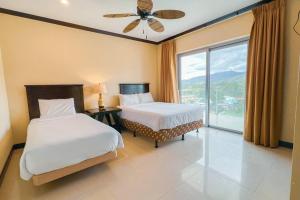 ハコにあるLuxury beach condo, stunning sunset & ocean viewのベッドルーム1室(ベッド2台、大きな窓付)