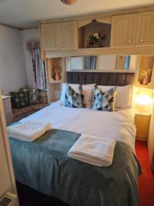 Portlaw的住宿－Mount bolton mobile home，一间卧室配有一张大床和两条毛巾