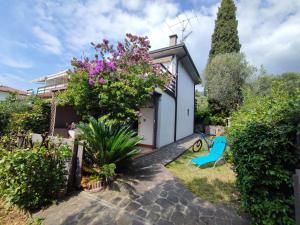 un jardín con una silla azul frente a una casa en Le Petit Nid, en Toscolano Maderno