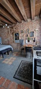 a kitchen with a table and a brick wall at Storico alloggio fronte piazza in Borgo Portello in Padova