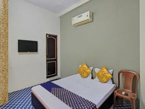 a small room with a bed and a chair at OYO Hotel G.K Lodging and Guest House in Sakardarā