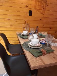a wooden table with plates and cups on it at Pousada Recanto da Cascata in São Joaquim +34 photos
