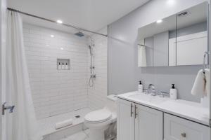a white bathroom with a toilet and a shower at The Ledger Residences by Sosuite - Old City in Philadelphia