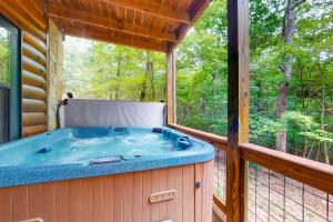 a jacuzzi tub on a screened in porch at Sleepy Bear Hideaway in Mineral Bluff