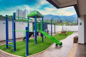 un parque infantil en la azotea de un edificio con un tobogán en Century, en Sabaneta
