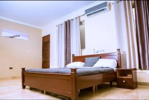 Schlafzimmer mit einem Bett und einem großen Fenster in der Unterkunft Home from Home GuestHouse in Accra