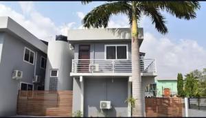 ein Haus mit einer Palme davor in der Unterkunft Home from Home GuestHouse in Accra