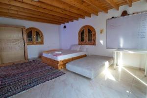 una habitación con dos camas y una pizarra blanca y una pizarra en Marine Garden Camp, en Dahab