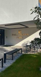 two benches sitting in front of a building at Apartament Park Partynice in Wrocław