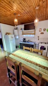 cocina con techo de madera y mesa en Llanten del Trébol en San Carlos de Bariloche
