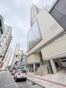 a street with cars parked in front of a building at Brisa Mar Apartamento Aconchego in Balneário Camboriú +31 photos