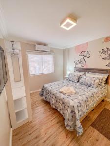 a bedroom with a bed and a window in it at Brisa Mar Apartamento Aconchego in Balneário Camboriú