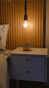 a nightstand with a bowl on it next to a bed at Paraiso Paulista Premium in Sao Paulo