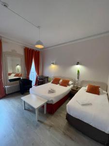 ein Hotelzimmer mit 2 Betten und einem Tisch in der Unterkunft Authentic by Balladins, Le Carré d'Aix in Aix-les-Bains