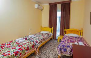 um quarto de hotel com duas camas e uma janela em Hotel Latif em Bukhara