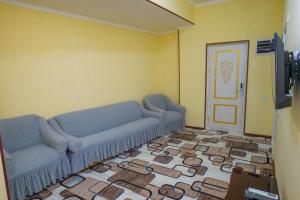 uma sala de estar com dois sofás azuis e um piso em Hotel Latif em Bukhara