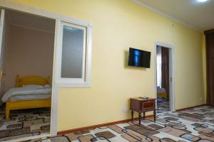um quarto com uma cama e uma televisão na parede em Hotel Latif em Bukhara